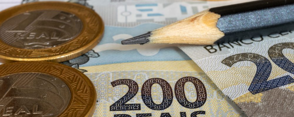 coins and banknotes of Brazilian money on the table. Selective focus.