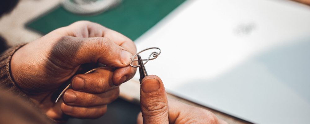Master using metallic thread to make jewelry. High quality photo