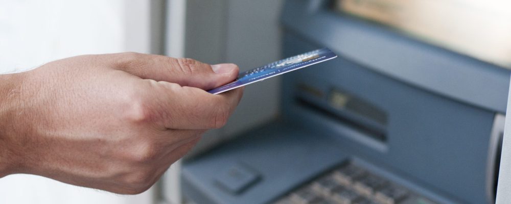 Hand inserting ATM card into bank machine to withdraw money. businessman men hand puts credit card into ATM