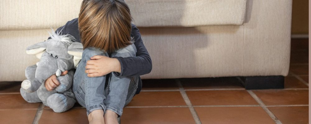 menino-chateado-ao-ar-livre-segurando-seu-brinquedo